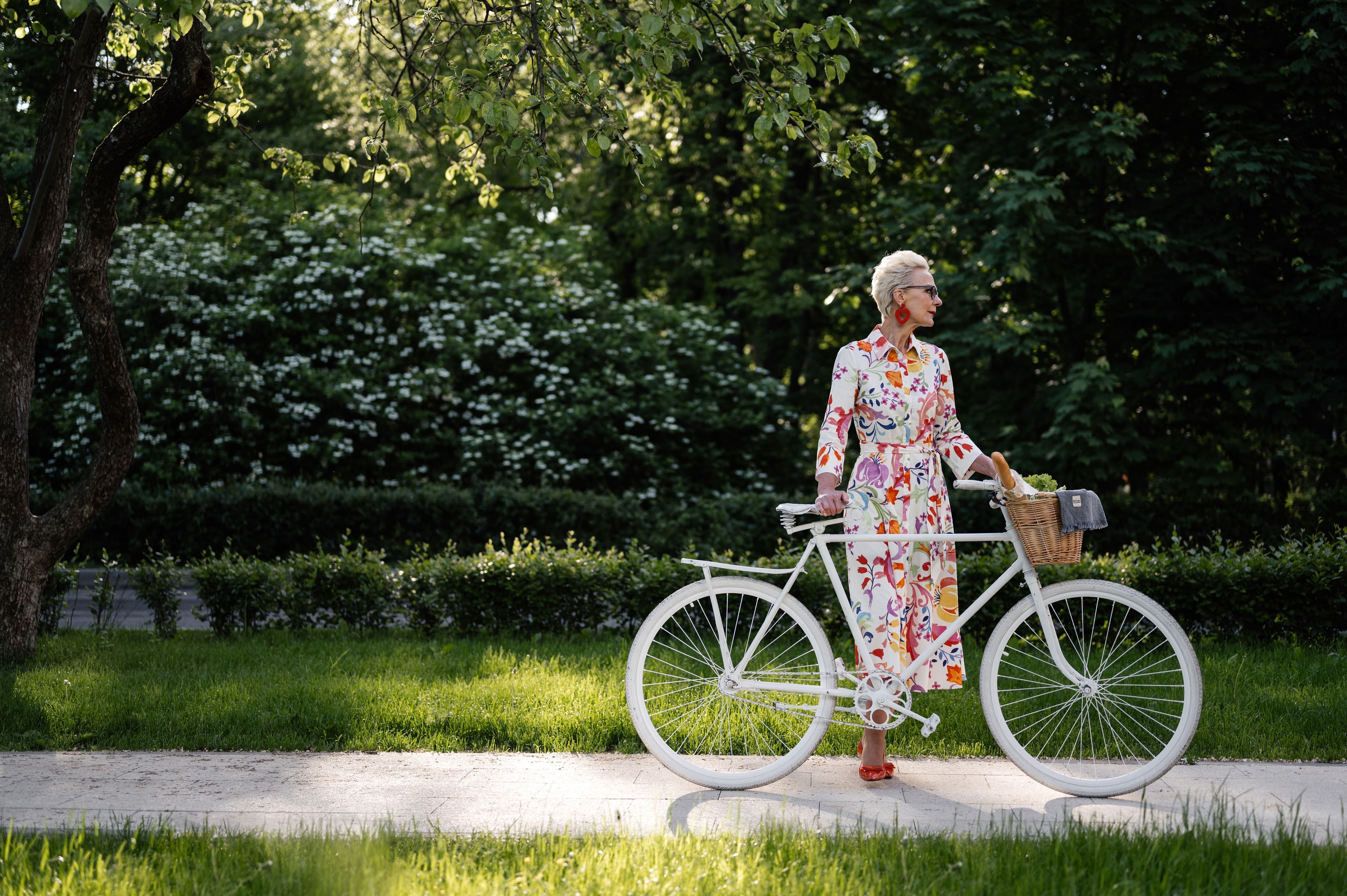 An active woman strolling through a park with her bicycle after vascular care